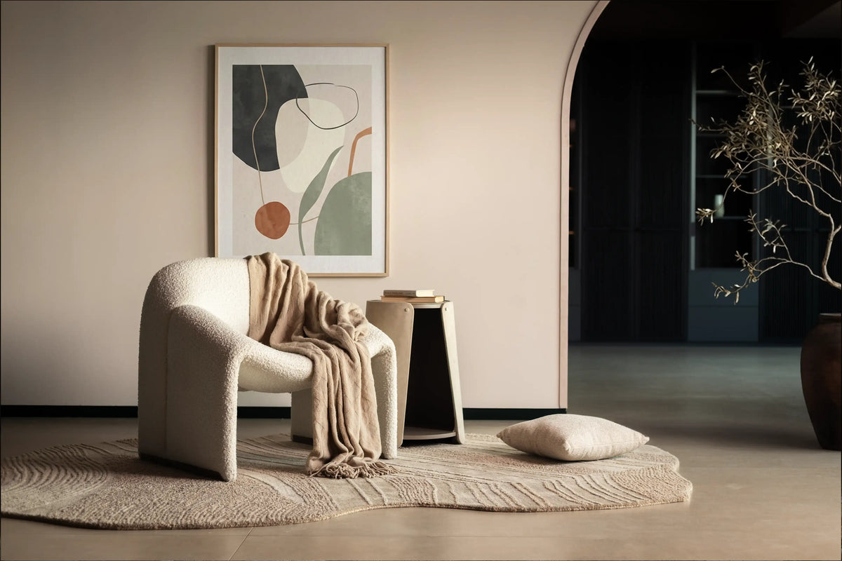 Modern interior with a textured armchair, abstract art, and decorative elements.