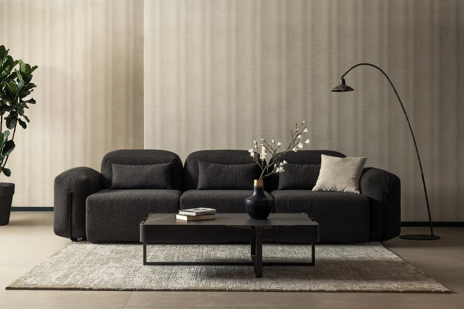 Modern living room with a dark gray sofa, coffee table, and decorative elements.