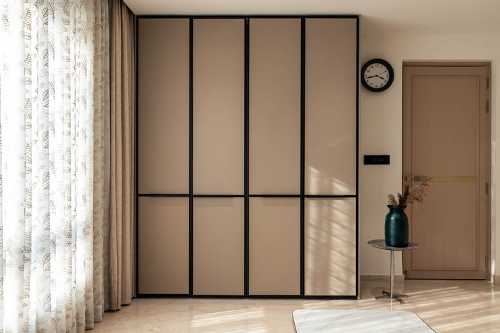 Modern interior with a large sliding door wardrobe, clock, and small table with a vase.1
