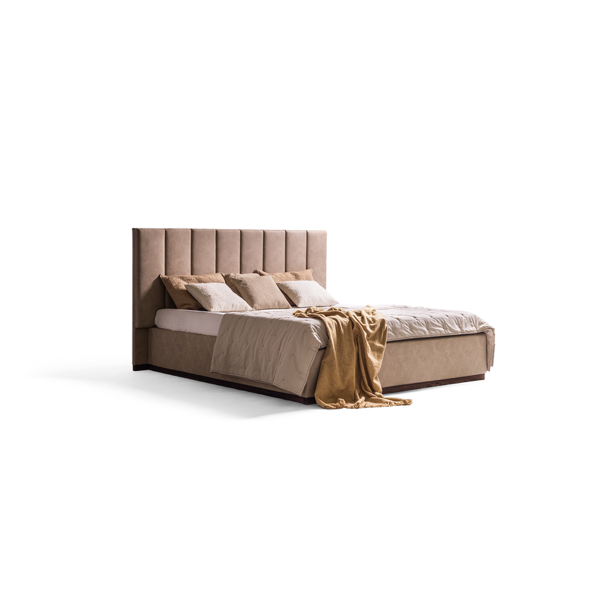 A modern platform bed with a tall, vertically channel-tufted upholstered headboard in a warm taupe fabric, styled with neutral beige and white bedding and a draped tan throw blanket, set against a plain white background.