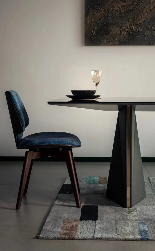 Dining room with a dark wooden table and chair, abstract painting on the wall.