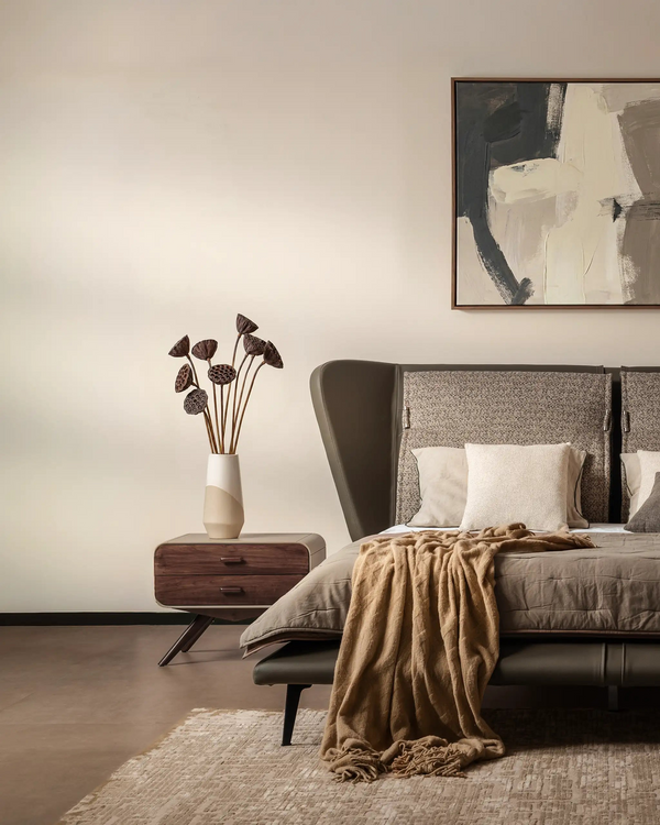 Modern bedroom with a large bed, side tables, and abstract art on the wall.