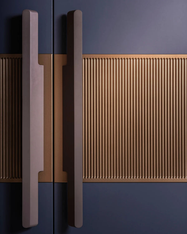Close-up of a golden shutter detail and metallic handle on a dark blue Wardrobe. VITTI Living 
